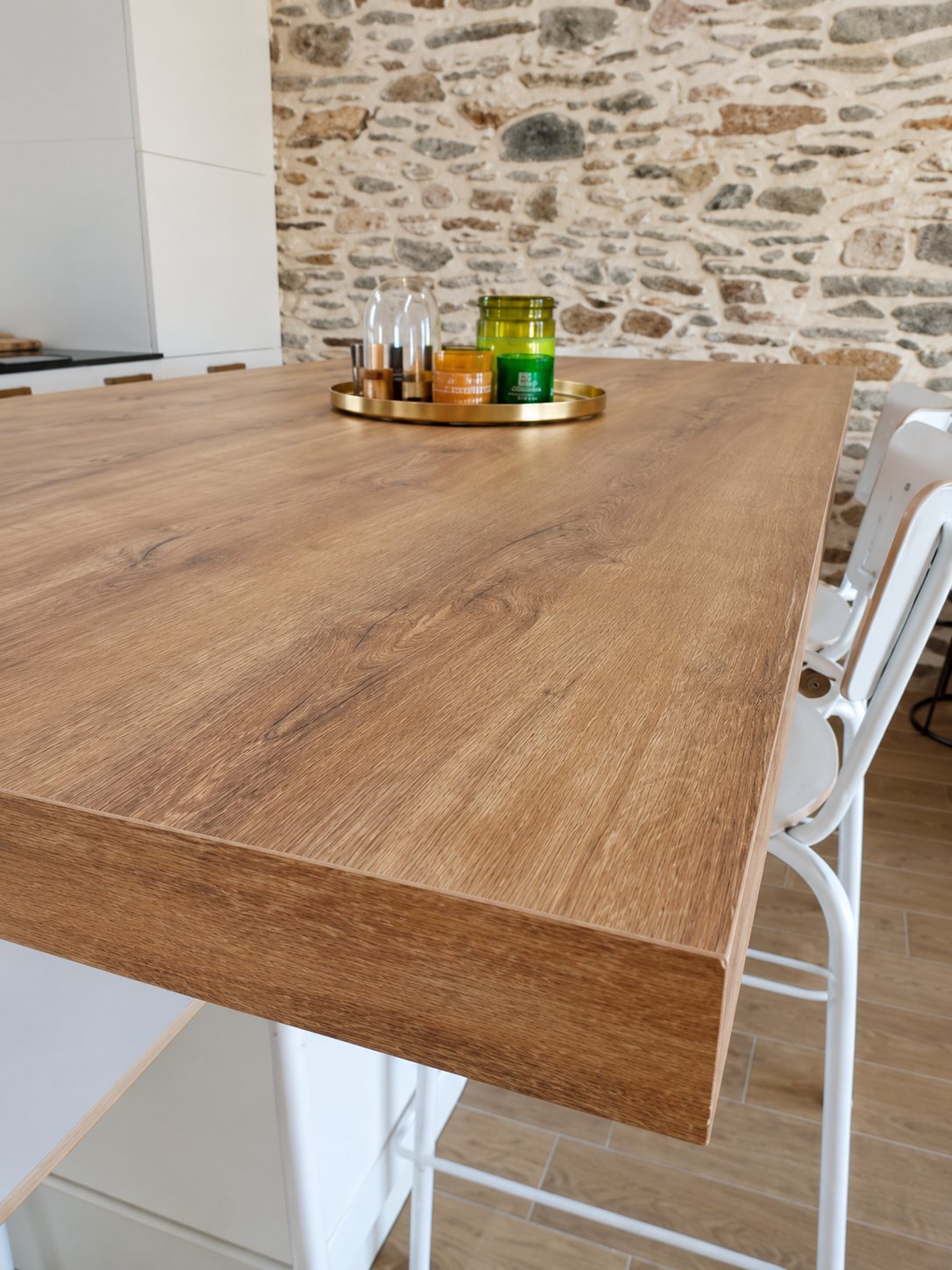 Angle d’un plan de travail en bois dans une cuisine, mur en pierre