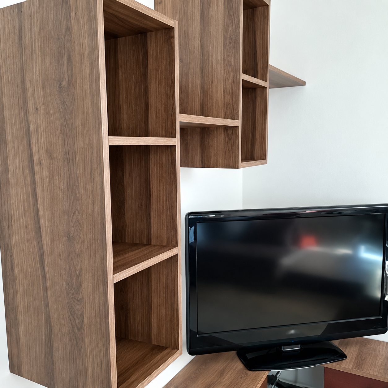 Détail d’un meuble TV en bois foncé avec étagères