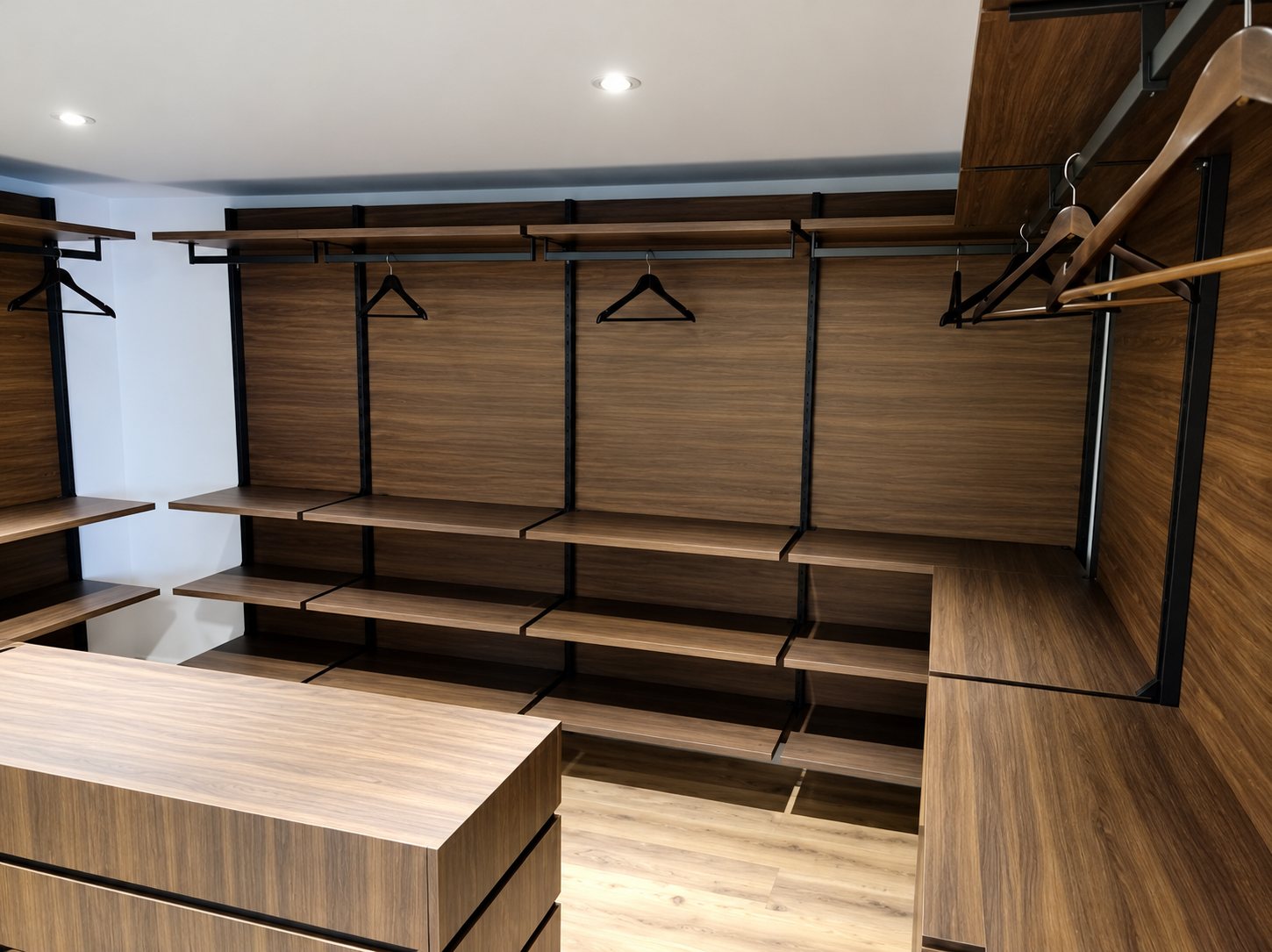 Dressing en bois foncé avec penderies et îlot-commode