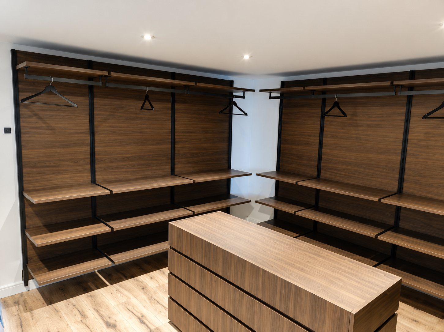 Dressing en bois foncé avec penderies et îlot-commode