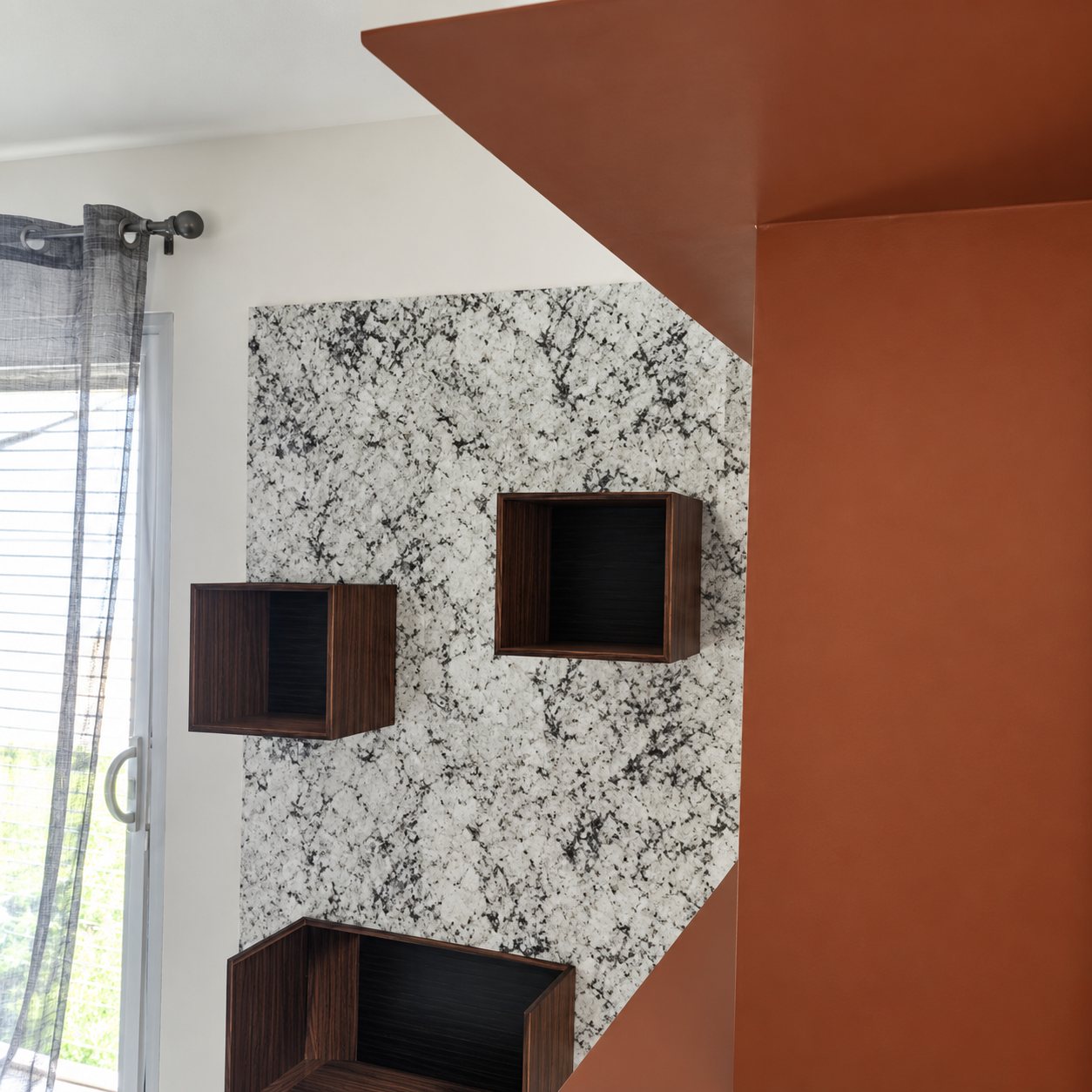 Cubes rouge brique et mur à motifs au-dessus d’un meuble TV