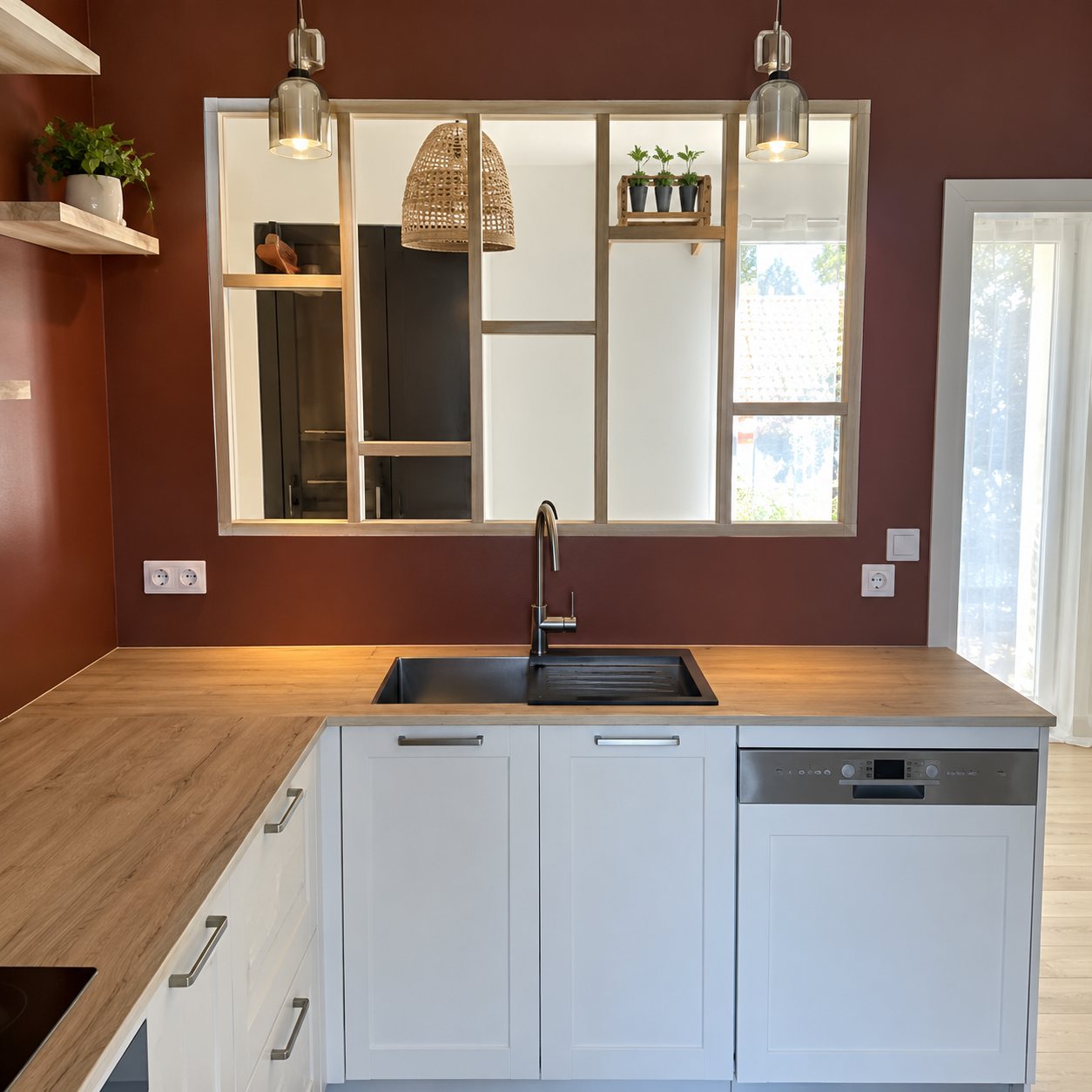 Verrière en bois au-dessus d’un évier dans une cuisine blanche à mur brique